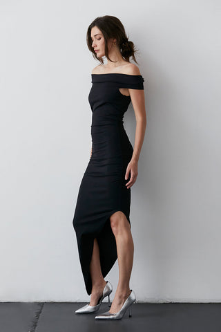 a model in a black midi dress with heels