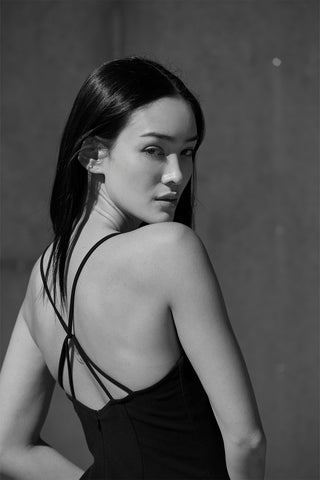 Close up of back criss cross detail of a woman wearing a dress.