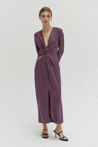 A woman wearing a textured satin dress with center front slit.