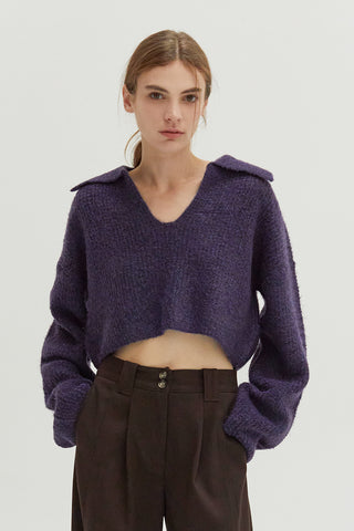 A woman wearing a waffle polo sweater.