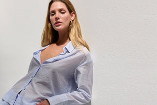 Woman in a blue semi sheer crinkled textured shirt