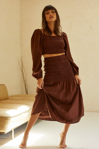 model wearing a brown two-piece skirt set