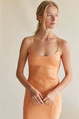 model wearing an orange satin midi dress