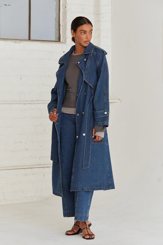 A woman wearing a denim trench coat. 