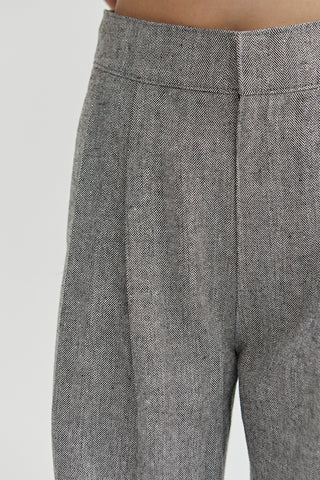 A woman wearing a herringbone pattern woven trousers. 