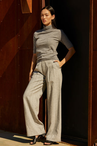 A woman wearing a herringbone pattern woven trousers. 