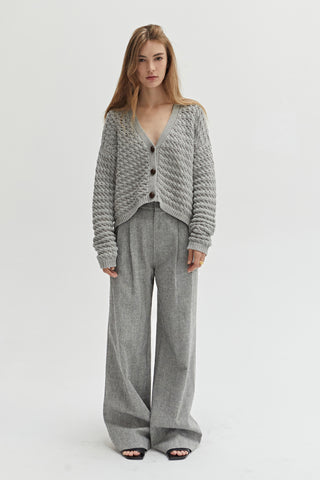 A woman wearing a herringbone pattern woven trousers. 
