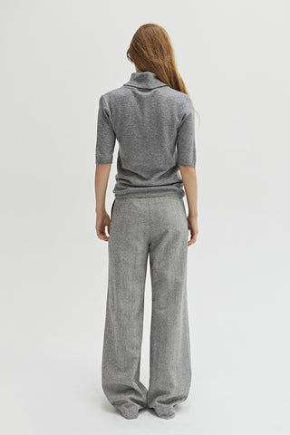 A woman wearing a herringbone pattern woven trousers. 