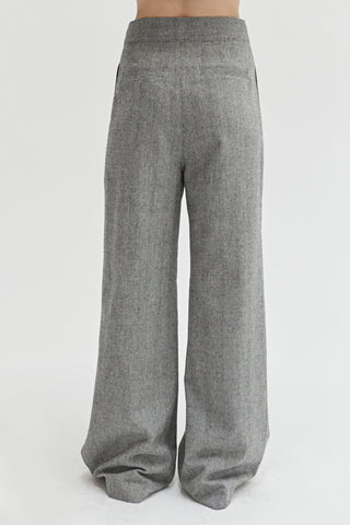 A woman wearing a herringbone pattern woven trousers. 