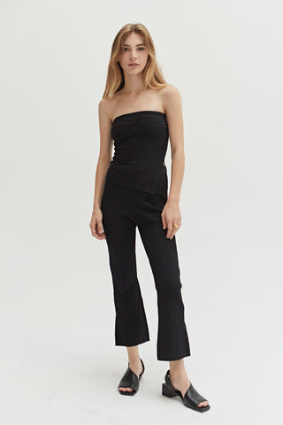 A woman wearing a black cropped stripe textured pattern knit pants with matching top.