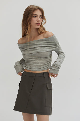 A woman wearing a dark olive cargo mini skirt.