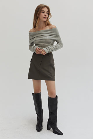 A woman wearing a dark olive cargo mini skirt.