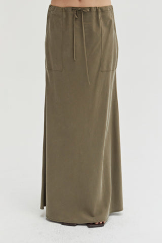 A woman wearing a green maxi skirt with drawstrings.