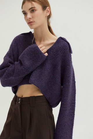 A woman wearing a waffle polo sweater. 