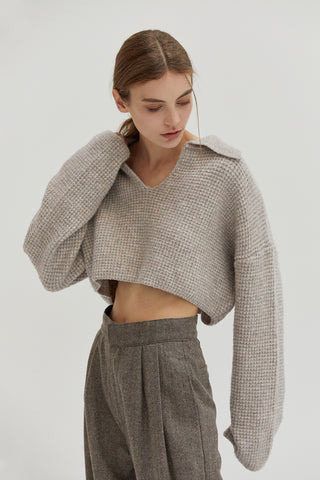 A woman wearing a waffle polo sweater. 