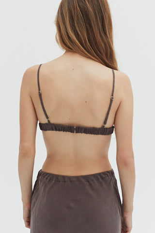 A woman wearing a cupro two piece bandeau & button up set.