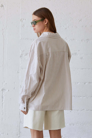 model wearing an oversized striped button-down shirt