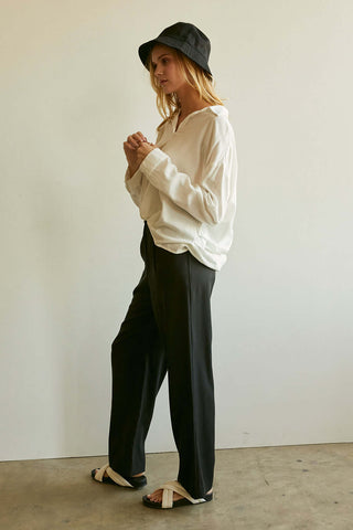 model wearing black pants and white blouse