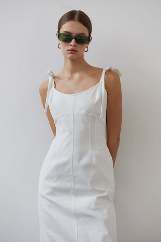 model wearing a white denim dress with sunglasses