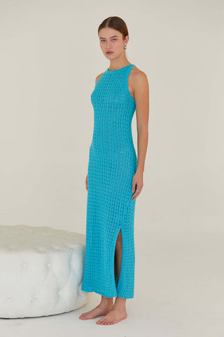 model wearing a teal sheath dress