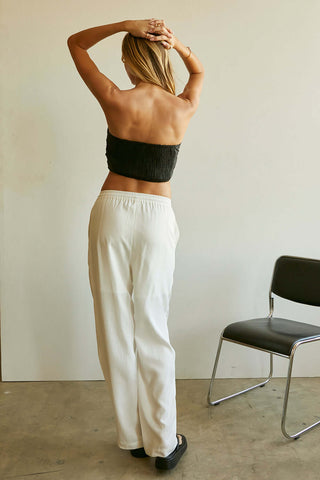 model wearing white pants and black crop top