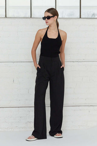 woman in black top looking to side with no shoes