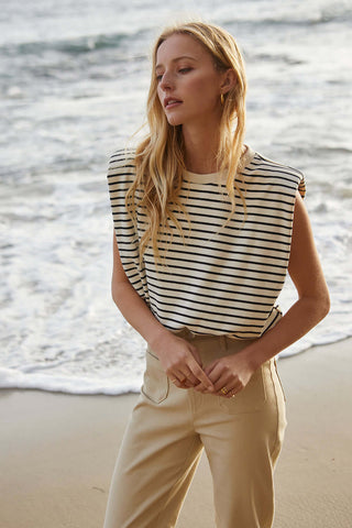 woman in striped top looking toward right with hands touching