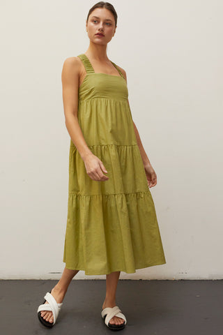 A model wearing a fern linen-bland criss-cross back tiered midi dress.