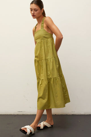 A model wearing a fern linen-bland criss-cross back tiered midi dress.