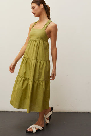 A model wearing a fern linen-bland criss-cross back tiered midi dress.