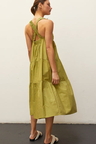 A model wearing a fern linen-bland criss-cross back tiered midi dress.