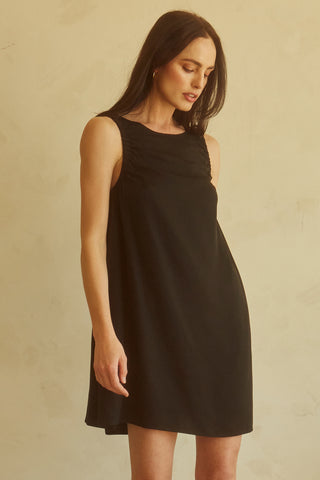 A woman wearing a black tencel mini dress.
