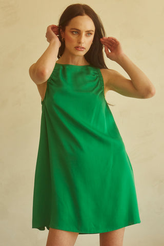A woman wearing an emerald tencel mini dress.