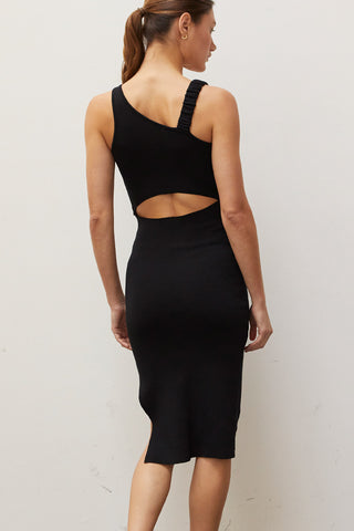 A woman wearing a black asymmetric shoulder with back cut out midi knit dress.