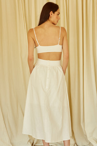 A woman wearing an ivory mixed media side cut out midi dress.