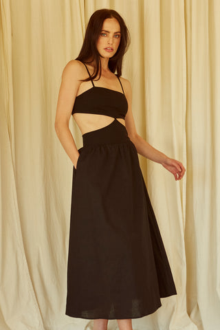 A woman wearing a black mixed media side cut out midi dress.