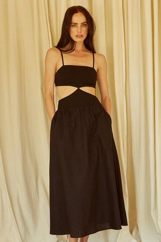 A woman wearing a black mixed media side cut out midi dress.