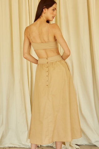 A woman wearing a taupe mixed media side cut out midi dress.