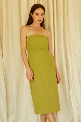A woman wearing a fern ruched bodice straight line midi dress.