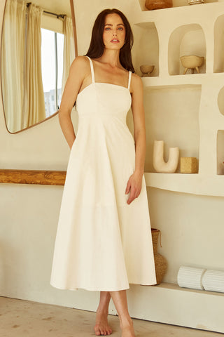 A woman wearing an ivory corset back midi linen dress.