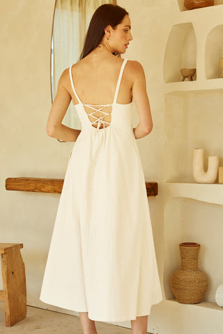 A woman wearing an ivory corset back midi linen dress.
