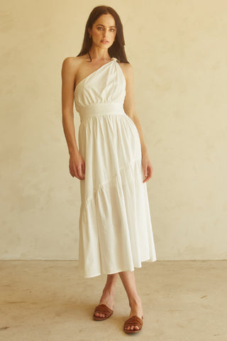 A woman wearing an ivory one-shoulder midi dress.