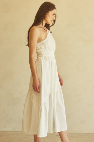 A woman wearing an ivory one-shoulder midi dress.