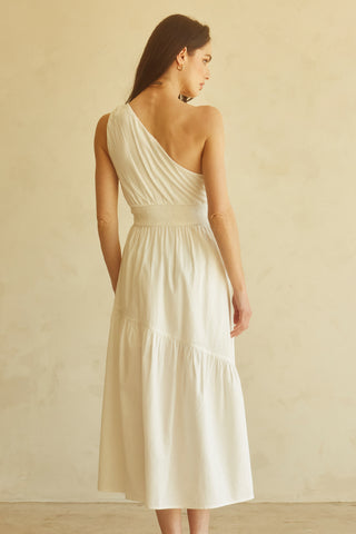 A woman wearing an ivory one-shoulder midi dress.