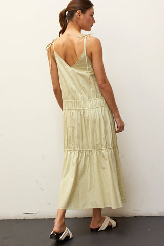 A woman wearing a sage multi tiered maxi dress.