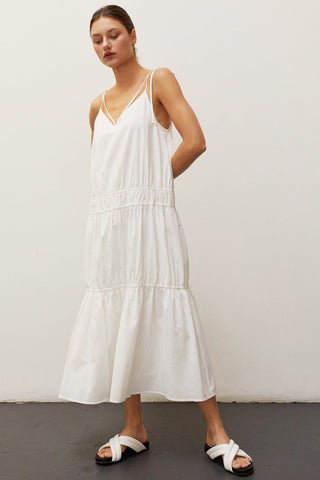 A woman wearing an ivory multi tiered maxi dress.
