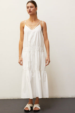 A woman wearing an ivory multi tiered maxi dress.