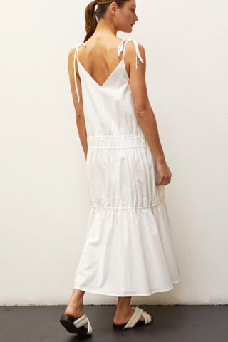 A woman wearing an ivory multi tiered maxi dress.