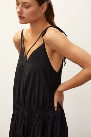 A woman wearing a black multi tiered maxi dress.