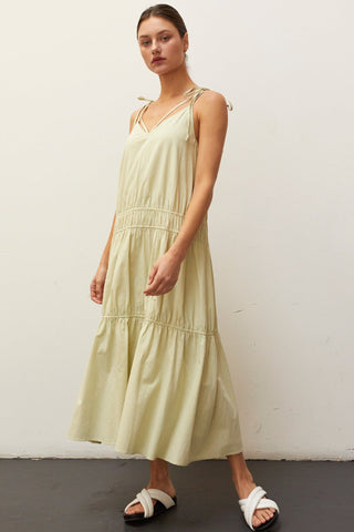 A woman wearing a sage multi tiered maxi dress.